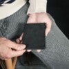 Man holding black bifold wallet
