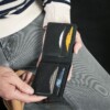 Man holding Black bifold wallet that holds credit cards