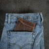 Manmade vintage brown passport wallet in jean pocket