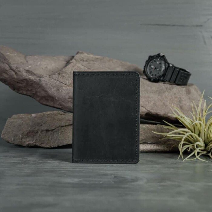 A closed, compact Black leather wallet