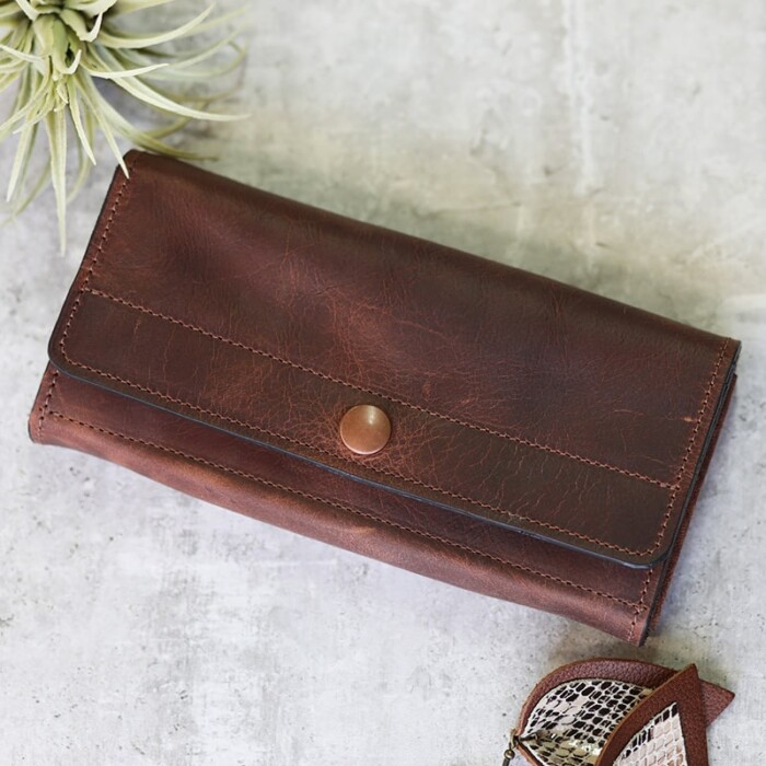 A women's reddish brown full grain leather wallet, displayed closed