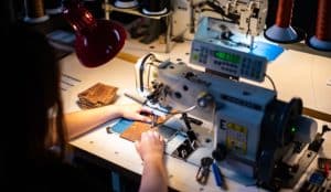 A Duvall Leatherwork artisan stitches together a quality leather wallet.