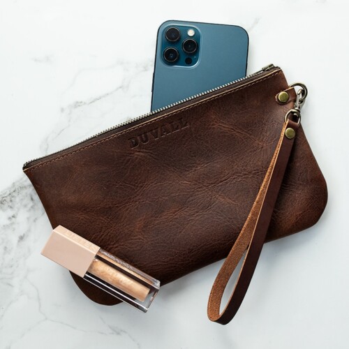 Red brown leather wristlet with blue iPhone and sparkle lip gloss.