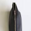 A women's black leather makeup bag shown from the top to highlight a copper-colored zipper