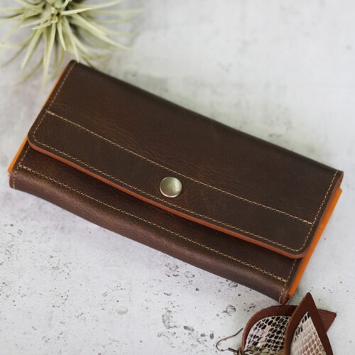 A dark leather wallet with orange leather accents