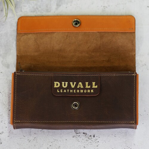 A full grain leather women's wallet in cedar brown and orange leather displated with the top flap open