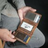 man showcasing trifold bison leather wallet holding credit cards
