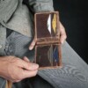 man holding handcrafted vintage brown leather wallet