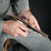 man pulling out money from a vintage brown bifold wallet