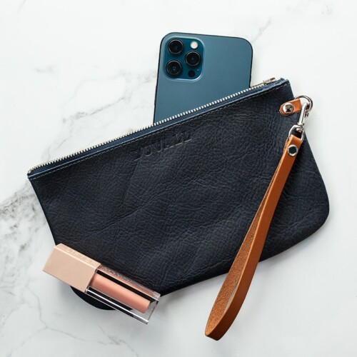 Navy blue leather wristlet with blue iPhone and sparkle lip gloss