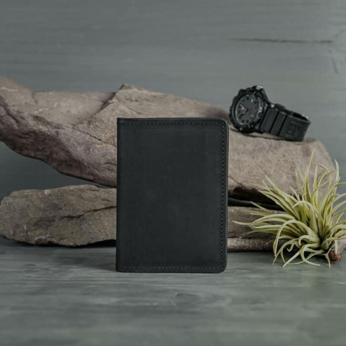 A closed, compact Black leather wallet