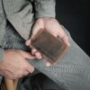 man holding vintage brown wallet that holds credit cards
