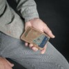 Man displaying a vintage brown leather money clip wallet
