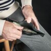 man dispencing money out of black trifold wallet
