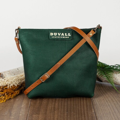 Forest green leather crossbody bag that has carmel color strap