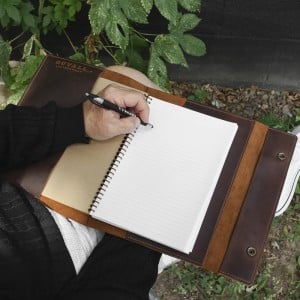 Man writting in large journal
