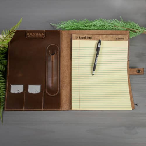 Opened leather padfolio with pen and legal pad.