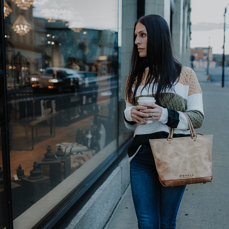 Woman window shopping with espresso cream charlene purse
