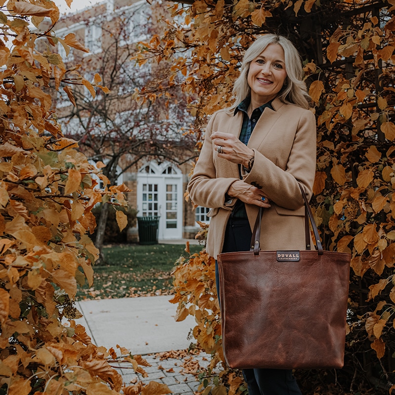 Business woman in blazer carrying red brown leather tote bag