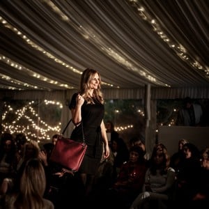 Runway fashion show model with crimson red slouch bag