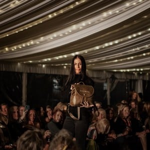 Model showcasing tundra green backpack purse at Duvall Leatherwork fashion show
