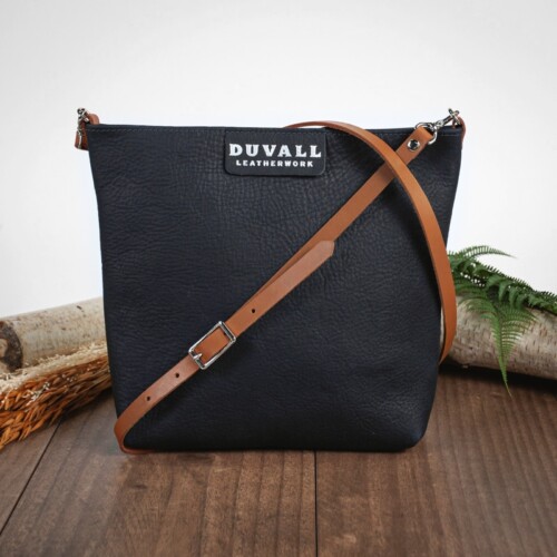 Navy blue leather cross body bag with carmel strap