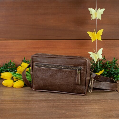 Dark brown fanny pack spring studio set up with wood background and tulips