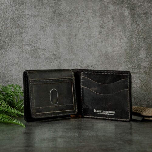 Inside a bifold wallet with ID window to hold multiple cards including your ID shot on slate background with greenery and pocket knife.