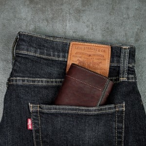Dark mahogany trifold that fits in your back jean pocket that's made to perfection shot on a slate tabletop.