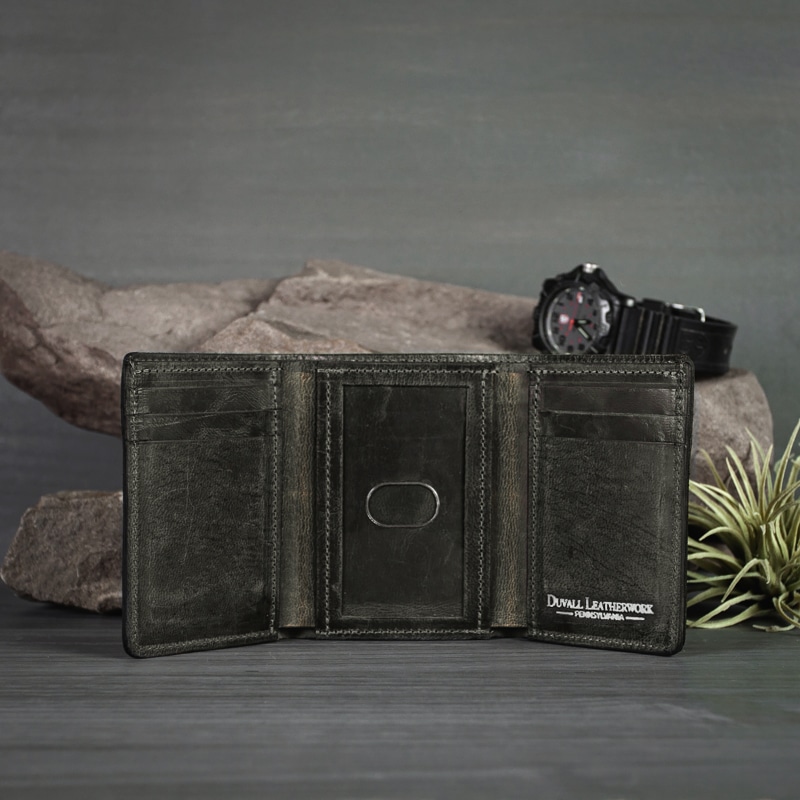 Inside an anthracite trifold wallet that has an ID window and card slots for all of your personal belongings shot in an outdoor studio setting.