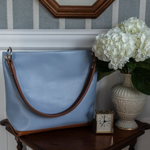 Light blue slouch handbag with brown leather bottom