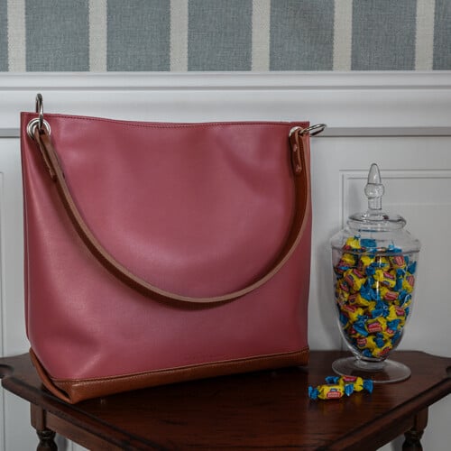 Pink leather slouch handbag with brown accents
