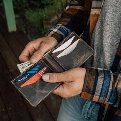 man holding a chocolate bison wallet open