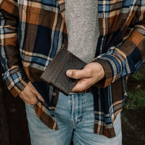 Man holding a chocolate bison bifold wallet