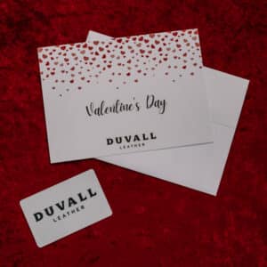 Photo of a white Duvall Leather gift card and Valentine's Day card with hearts on a red velvet backdrop